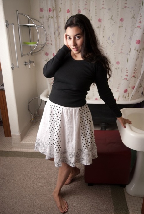 Plump young brunette Wara disrobes in the bathroom to spread hairy pussy lips